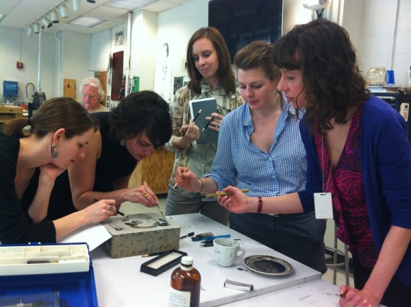 Photograph of Phillips educators and curators working together to create a lithograph taken by Brooke Rosenblatt.