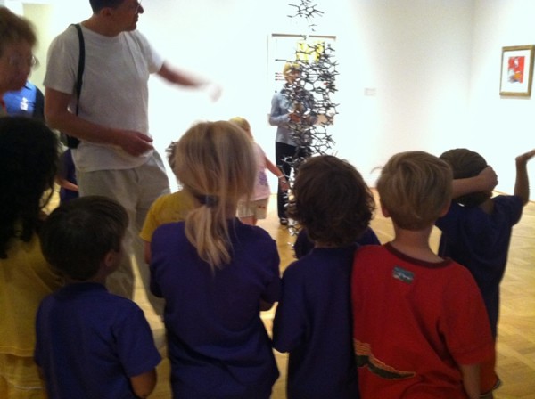 Antony Gormley and a group of children discuss his sculpture