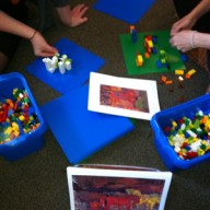 Phillips staff with bins of legos, creating sculptures