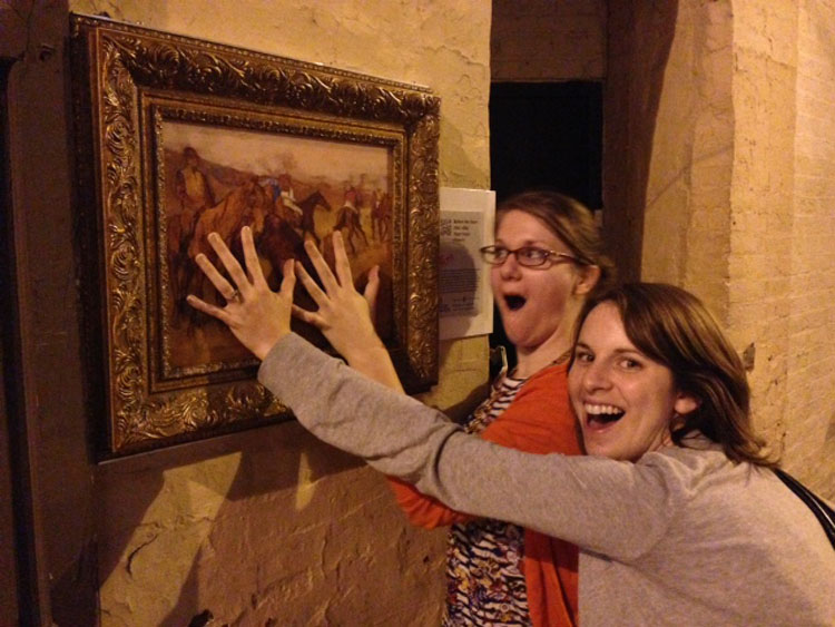 Natalie Mann and Meagan Estep excitedly palm a reproduction of Degas' Before the Race, on display on a street in Baltimore, via The Walters Art Museum. Photo: Margaret Collerd