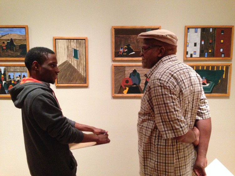 A student asks an elder about his life while looking at The Migration Series.  Photo: Andrea Kim Taylor